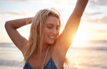 happy woman stretches against the sunset