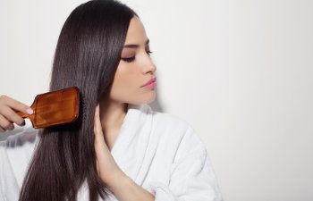 beautiful woman combs her dark long hair with a brush Atlanta, GA