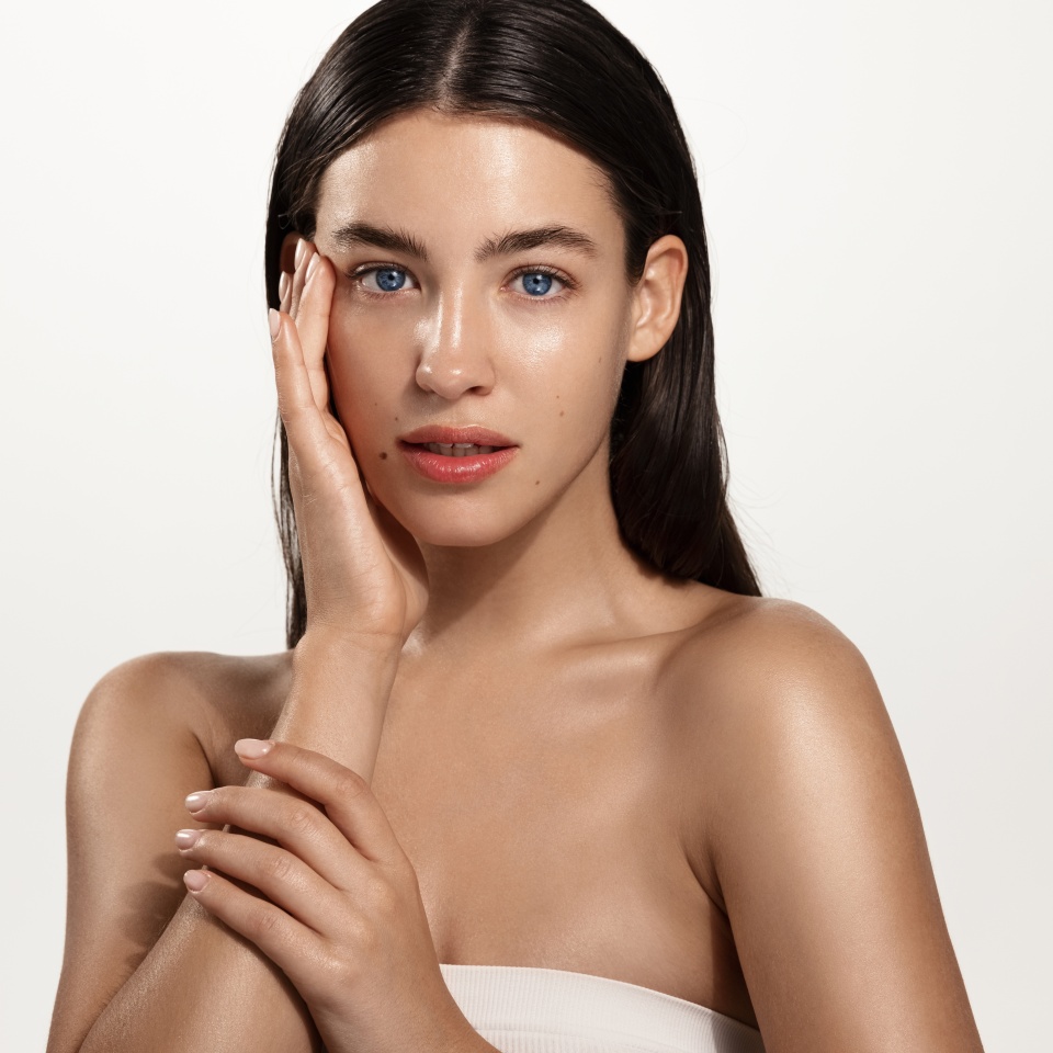 Skin care and women beauty. Young spa girl with clean body and natural facial tone, no makeup, touching her cheek and gazing at camera, advertising cosmetic product