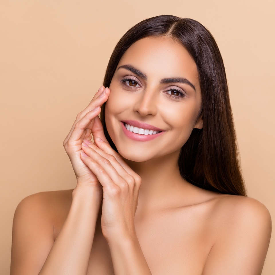 Portrait of attractive cheery girl touching smooth silky flawless soft skin isolated over beige pastel color background