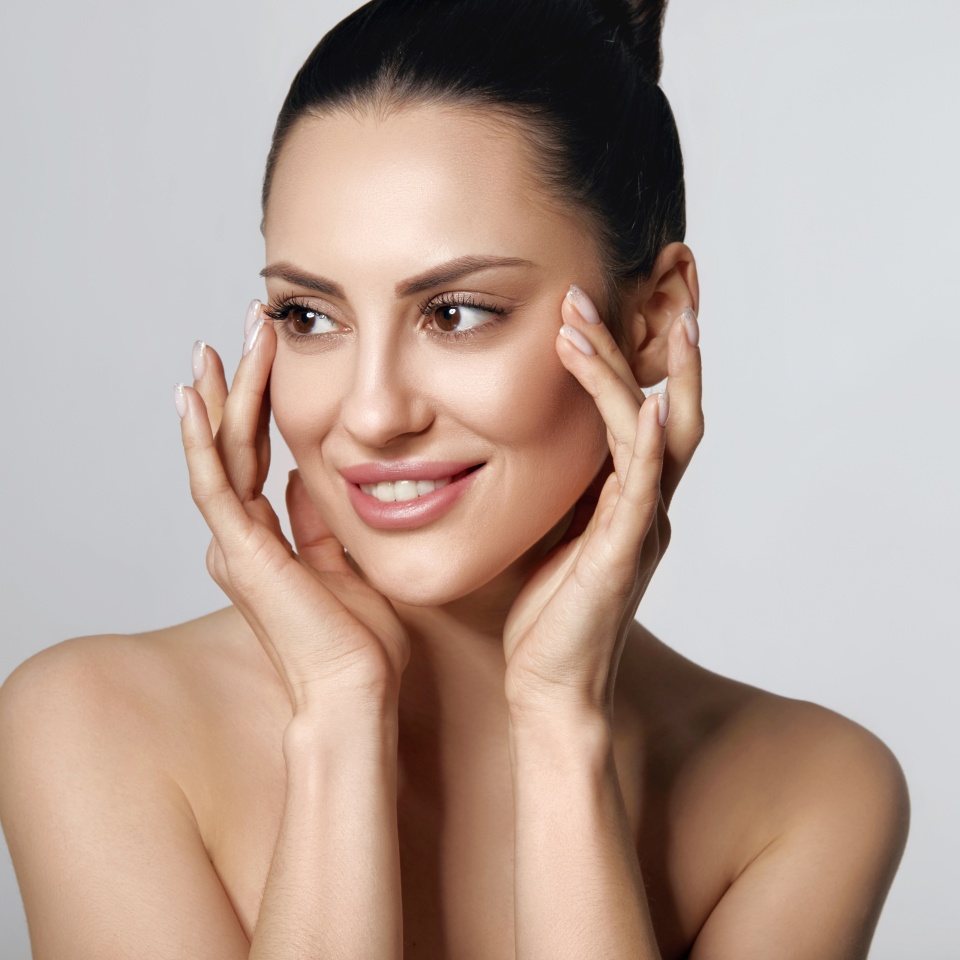 Happy Beautiful Girl Holding Her Cheeks With A Laugh Looking To The Side. Pretty Woman Clean Fresh Skin.Cosmetology, Beauty And Spa.