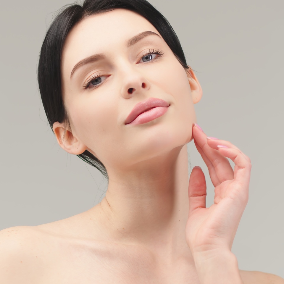 Portrait of a young woman isolated on a light background. Skin care. Beautiful female model with perfectly clean fresh skin. Natural beauty and cosmetology concept
