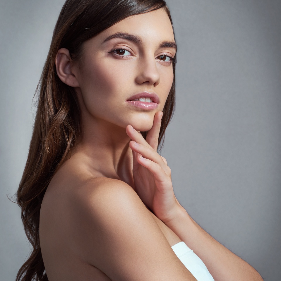 Portrait, thinking and beauty of woman with glow, skincare or health isolated on gray studio background. Face, makeup and confident model in cosmetics at spa for dermatology, wellness and aesthetic