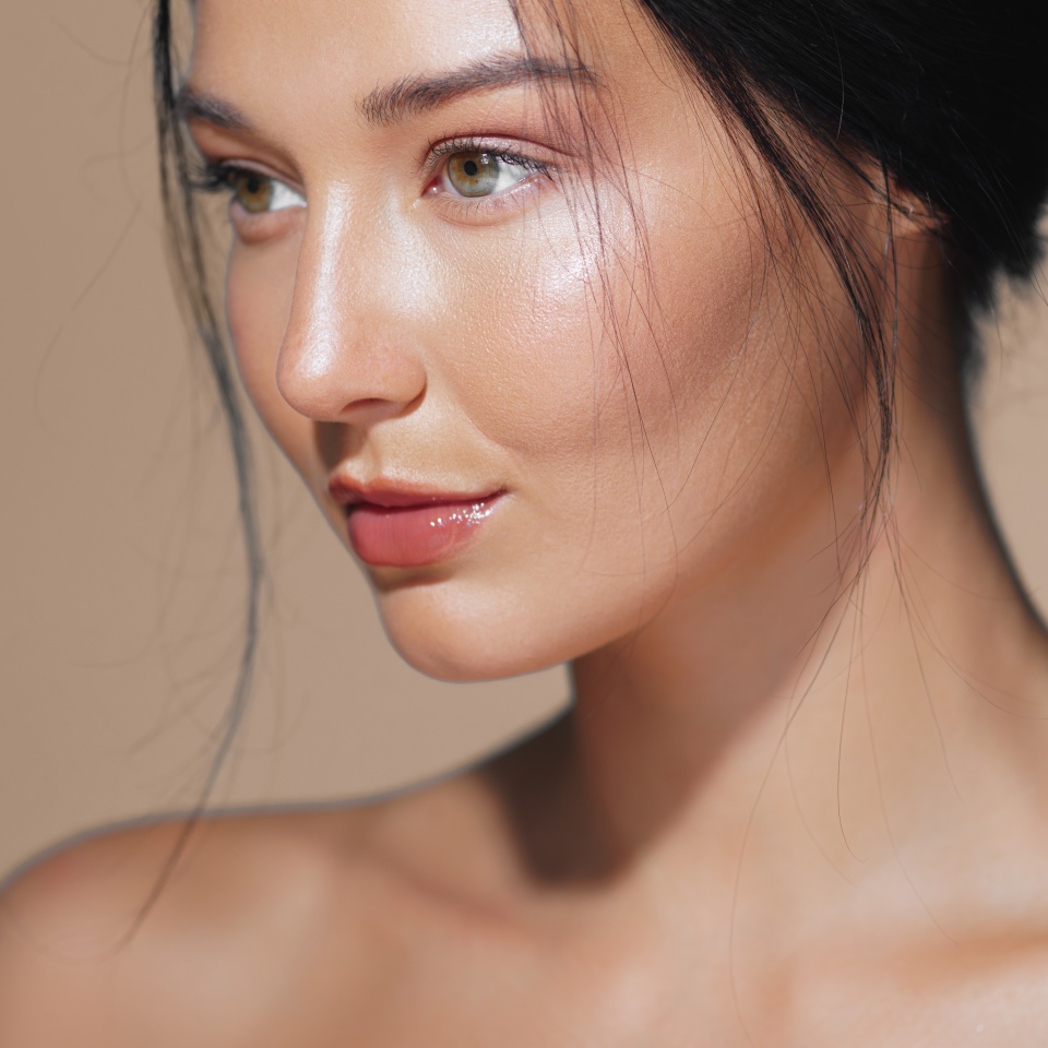 Close-up of a beautiful Asian woman with glowing skin, posing in a studio setting. Ideal for beauty, skincare, and cosmetics advertisements. High quality image for conceptual and promotional use.